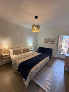 a bedroom with a large bed and a chandelier at Casa Eva in Dolceacqua