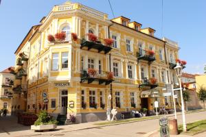 un edificio giallo con fiori sui balconi di una strada di LD PALACE II Spa & Kur a Františkovy Lázně