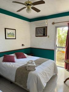 a bedroom with a bed with a ceiling fan at Hotel Village Termas de Dayman in Termas del Daymán +80 photos