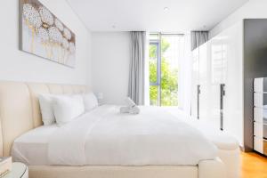 een witte slaapkamer met een groot wit bed bij Island Paradise - Stylish 1BR on Bluewaters Island in Dubai +38 foto's
