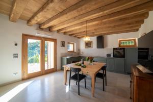 a kitchen with a wooden table and black chairs at Casa Capitania in Farra di Soligo