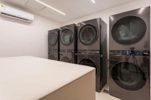 a laundry room with four washer and dryers at Acogedor loft a pasos de todo in Asuncion