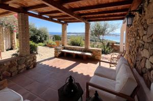 a patio with a bench on a stone wall at Domus Sole in Campu Longu