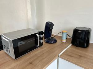 a microwave sitting on a counter next to a blender at Charmant appartement T2 Parc de la Verrerie Confort in Le Creusot