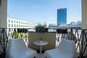 a balcony with two chairs and a table on a balcony at Charming 2-BR apartment at Nivy Bratislava in Nivy