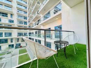 un balcone con tavolo e sedie e un edificio di ZAPBED HOUSE -Rak F 201 a Ras al Khaimah