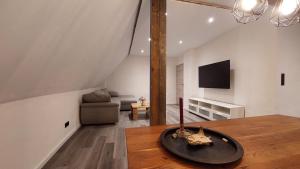 a living room with a table and a tv and a couch at Ferienwohnung Auszeit Osterode in Osterode