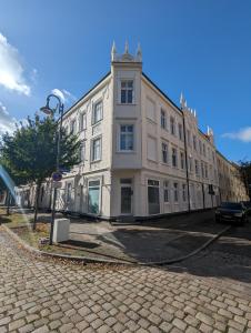 un grand bâtiment blanc au bord d'une rue dans l'établissement 3-Zimmer Apartment in Wittenberge, à Wittenberge