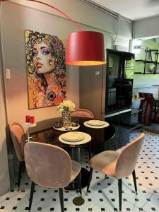 ein Esszimmer mit Tisch und Stühlen und einem Gemälde in der Unterkunft Wiang Ping house in Chiang Mai