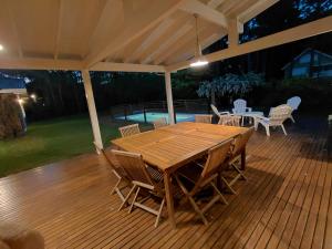 a wooden table and chairs on a deck at night at Casa grande Carilo in Carilo