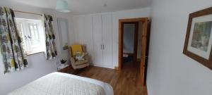 a bedroom with a bed and a hallway with a window at Felicity Cottage, W91 D1W3 in Kiltegan