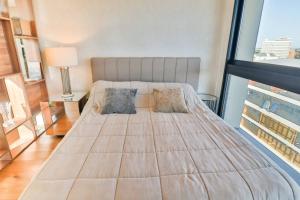 un grand lit dans une chambre avec une grande fenêtre dans l'établissement New Studio by Shop del Sol in Prime Location, à Asuncion 28 autres photos