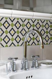 a sink with two faucets in a bathroom at Un air de bourlingueurs in Pepinster +27 photos