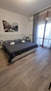a large bed in a bedroom with a wooden floor at Sunny CentralApartment -3 bedrooms ,Private Parking in Monfalcone