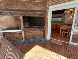 an outdoor kitchen with a brick wall and wooden deck at Casa grande Carilo in Carilo