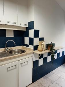 een keuken met een wastafel en blauwe en witte tegels bij Lisbon Apartment HomeMode Príncipe Real 
