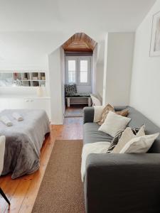 een woonkamer met een bank en een bed bij Lisbon Apartment HomeMode Príncipe Real 