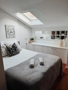 een slaapkamer met een bed en slippers bij Lisbon Apartment HomeMode Príncipe Real 