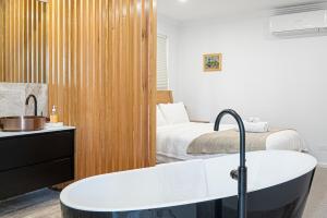 a bathroom with a bath tub next to a bed at Luxe on Seacrest in Encounter Bay