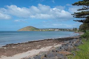 a view of a beach with a mountain in the background at Luxe on Seacrest in Encounter Bay +12 photos
