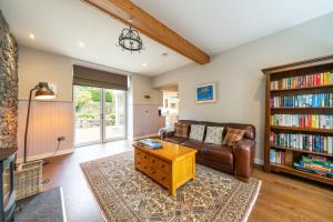 a living room with a couch and a book shelf at Stables Cottage in Dunira
