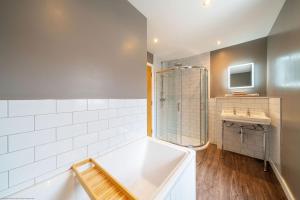 a bathroom with a tub and a sink at Stables Cottage in Dunira +42 photos