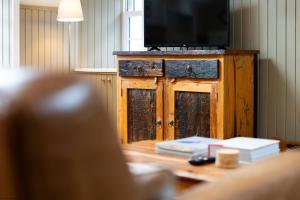 a television on top of a wooden cabinet at The Granary in Dunira +37 photos