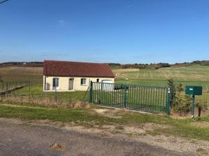 una recinzione di fronte a una casa in un campo di La petite maison a Buchey