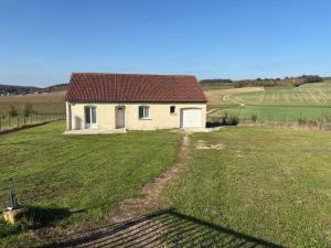 a small white house in the middle of a field at La petite maison in Buchey