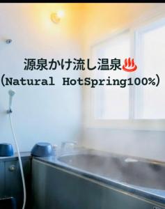a bathroom with a sign on the wall at 源泉かけ流し温泉付き一棟貸しVilla Gensen Two in Yuzawa