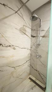a shower in a bathroom with white marble at Stylish Sahloul 4 Apartment with Balcony in Sousse +6 photos