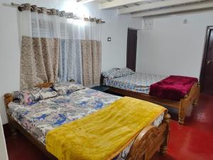 una habitación con dos camas en una habitación en Doddagadde Stays, en Sakleshpur