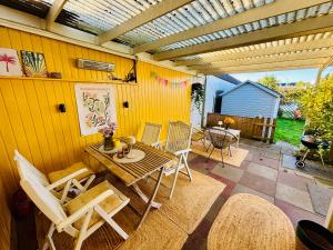 d'une terrasse avec une table et des chaises en bois. dans l'établissement BeachBüdchen in Haffkrug, à Scharbeutz 5 autres photos