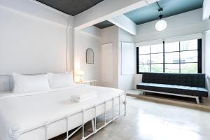 Bang KapiにあるX Yellow Place Sukhumvit Soi 2 - เยลโล เพลส สุขุมวิทซอย 2の白いベッドルーム(大型ベッド1台、ソファ付)