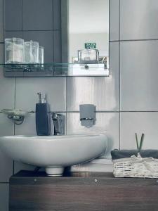 a bathroom with a white sink and a mirror at Apartman Safir 1 & Apartman Safir 2 & Apartman Safir 3 in Kruševac