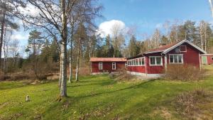 a red house in the middle of a field at Mormors hus in Jörlanda