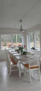 a white dining room with a white table and chairs at Mormors hus in Jörlanda +20 photos