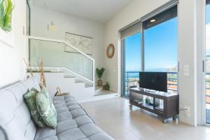 a living room with a couch and a flat screen tv at Pitanga by Atlantic Holiday in Panasqueira