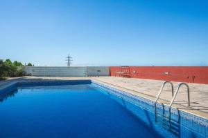 a swimming pool with blue water next to a red wall at Pitanga by Atlantic Holiday in Panasqueira