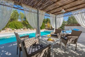 a patio with a table and chairs next to a swimming pool at Villa Sa Fontasa in Moscari