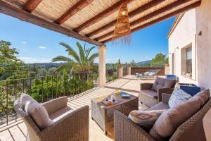 a patio with chairs and a table on a balcony at Villa Sa Fontasa in Moscari