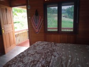 a bedroom with a bed and a large window at Homestay Alina in Tomohon