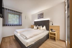 a bedroom with a large bed and a table at Apartments Raffl in San Pietro in Gardena