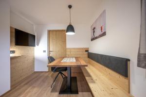 a kitchen and dining room with a wooden table and chairs at Apartments Raffl in San Pietro in Gardena