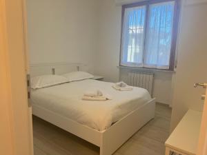 a bedroom with a white bed with towels on it at Vicino aeroporto Pisa - Wi-Fi e parcheggio gratuito in Pisa