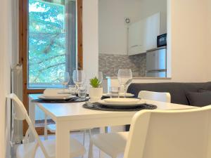 a white dining room table with wine glasses on it at Vicino aeroporto Pisa - Wi-Fi e parcheggio gratuito in Pisa