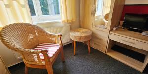 海利根达姆Mollibahnhof - Heiligendamm Mollibahnhof Heiligendamm EZ 03的带椅子和电视的客厅