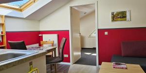 a kitchen with a sink and a red wall at Mollibahnhof - Heiligendamm Mollibahnhof Ferienwohnung 05 in Heiligendamm