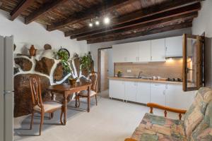 a kitchen with white cabinets and a table and chairs at La Generosa in Arona +10 photos