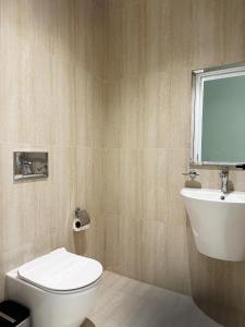 a bathroom with a toilet and a sink and a window at Mabaat-Executive 3BR-Al Narjis - 619 in Riyadh +15 photos